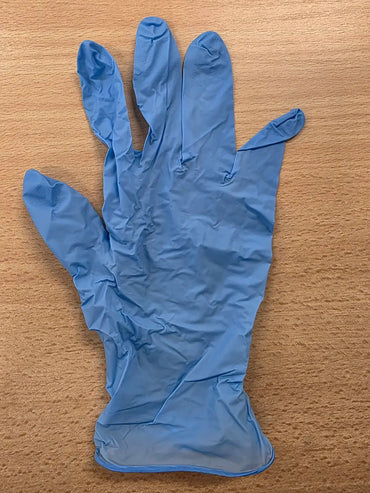Titan powder free nitrile gloves in blue laid flat on wooden surface for protective use