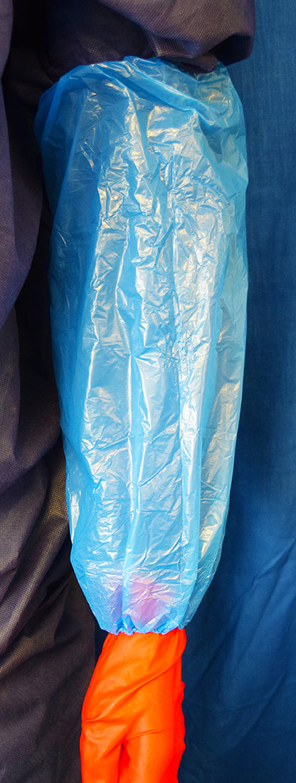 Mediflex blue PE arm protectors covering an arm over orange gloves for PPE safety